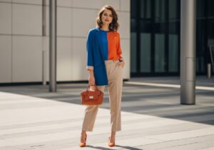 Mladá žena v městském prostředí s barevným outfitem a koženou kabelkou, přirozený vzhled, denní světlo